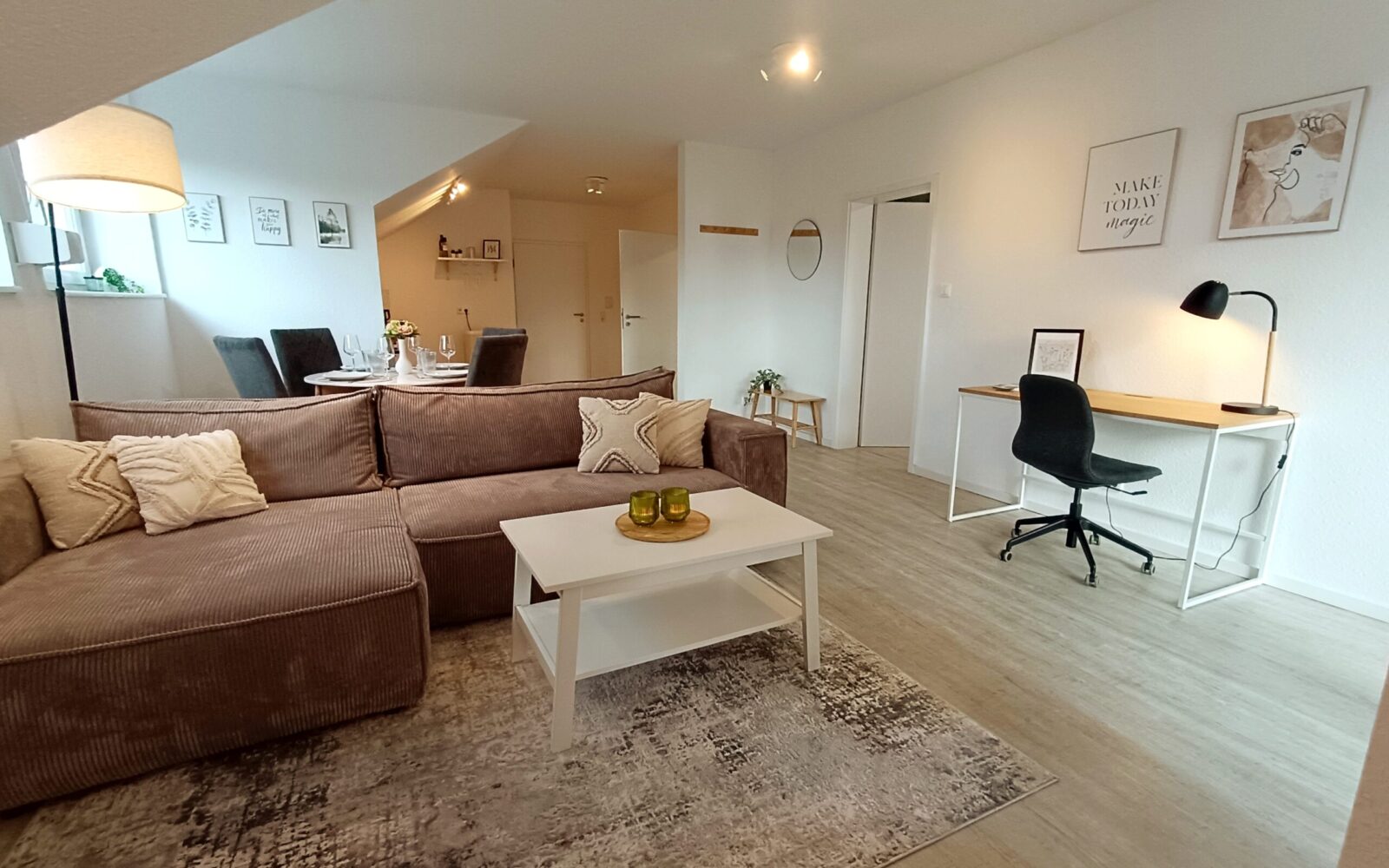 Modernes Wohnzimmer der Ferienwohnung in Arnsberg mit Sofa, Smart-TV und Zugang zum Balkon