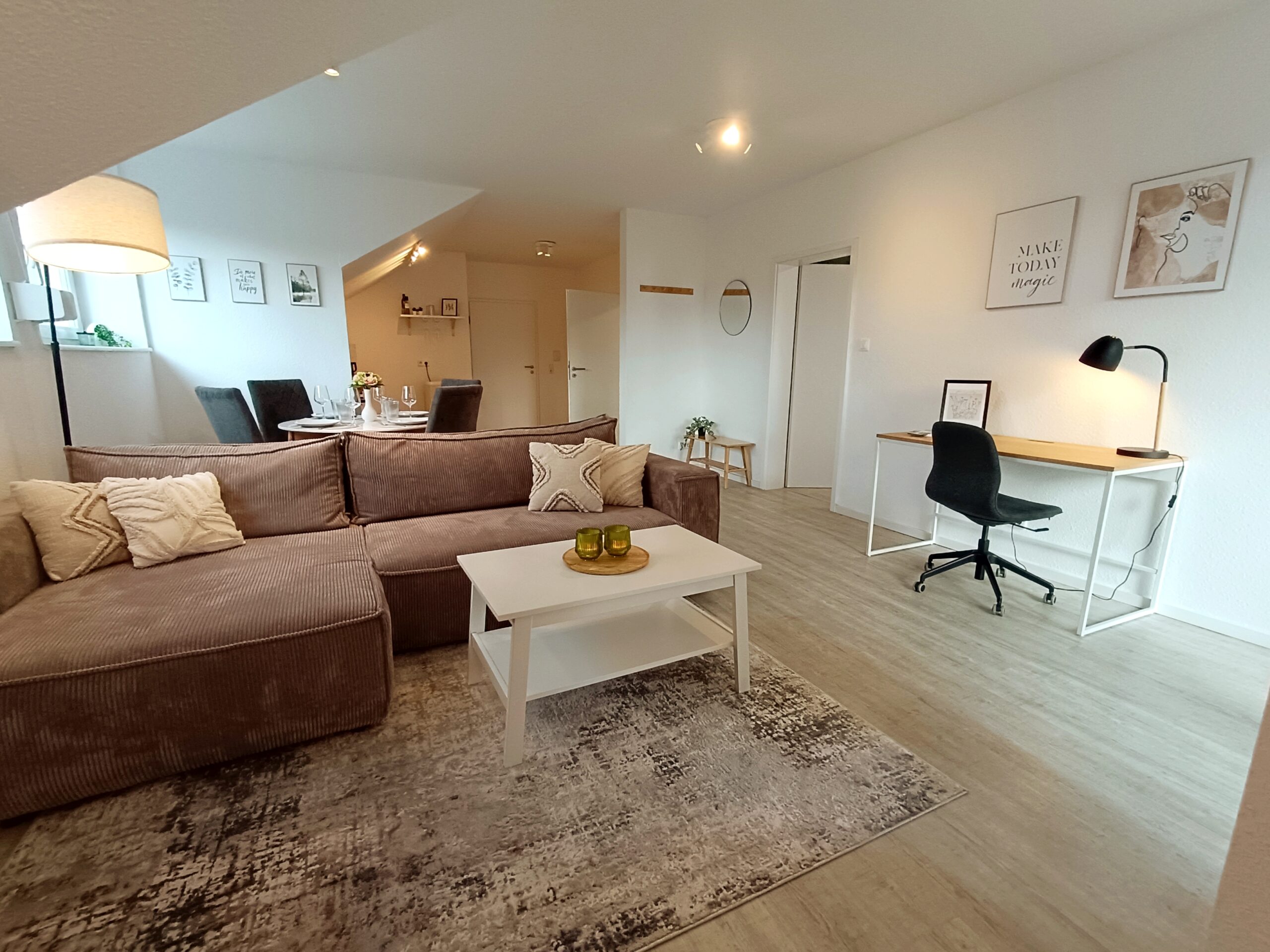 Modernes Wohnzimmer der Ferienwohnung in Arnsberg mit Sofa, Smart-TV und Zugang zum Balkon